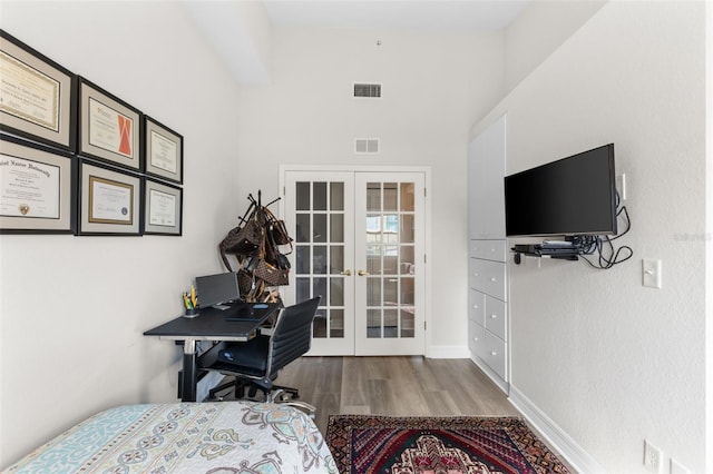 bedroom with french doors and wood finished floors