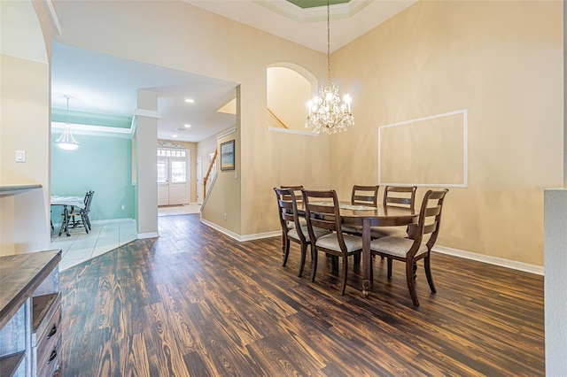 dining room with dark hardwood / wood-style floors and an inviting chandelier