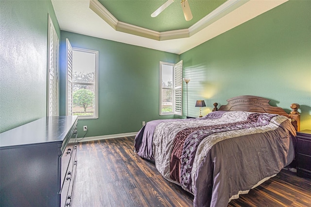 bedroom featuring ceiling fan, dark hardwood / wood-style floors, crown molding, and a tray ceiling