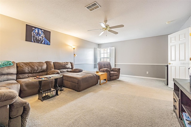 living room with a textured ceiling, ceiling fan, and light carpet