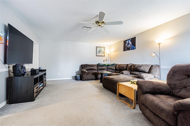 living room with a textured ceiling, carpet floors, and ceiling fan