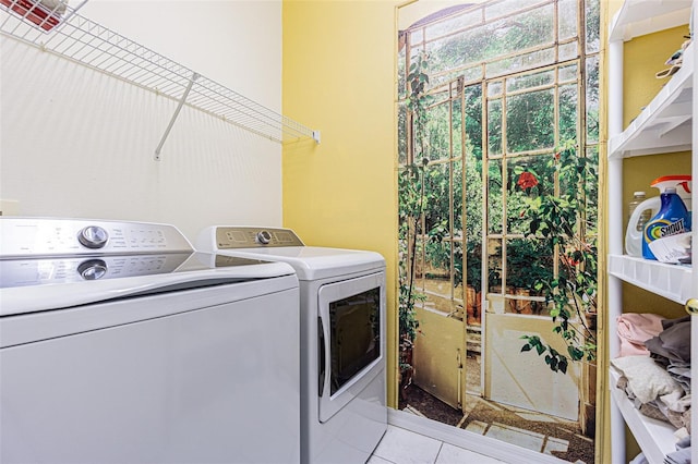 laundry room featuring washing machine and clothes dryer and light tile patterned floors