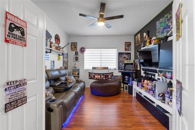 living room with a textured ceiling, dark hardwood / wood-style flooring, and ceiling fan