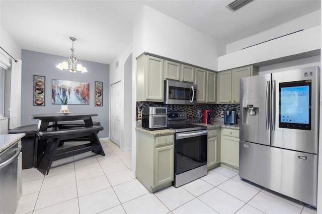 kitchen with green cabinets, light stone countertops, stainless steel appliances, and an inviting chandelier