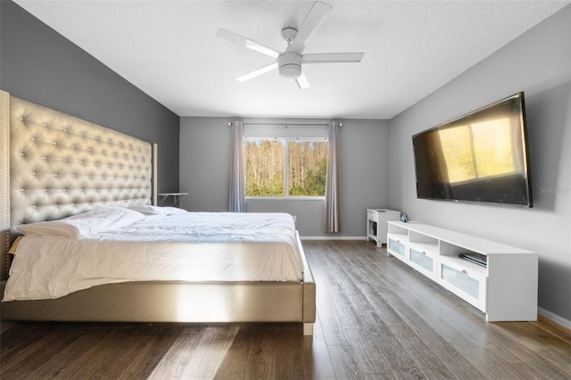 bedroom with hardwood / wood-style floors, ceiling fan, and a textured ceiling