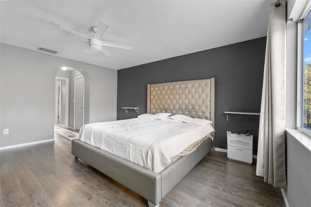 bedroom featuring a textured ceiling, hardwood / wood-style flooring, multiple windows, and ceiling fan