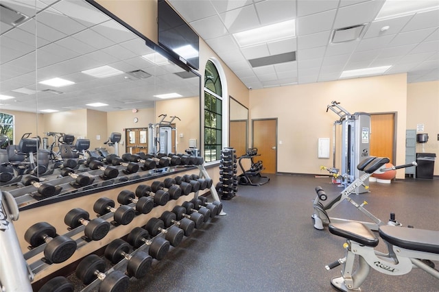 exercise room featuring a drop ceiling and a healthy amount of sunlight