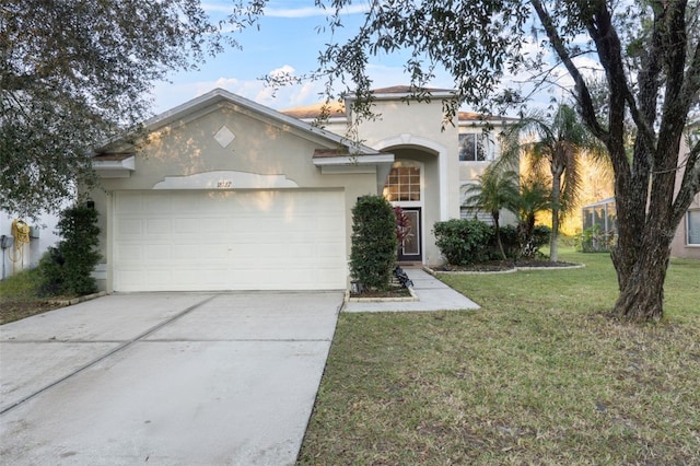 view of front facade with stucco siding, a front lawn, concrete driveway, and a garage