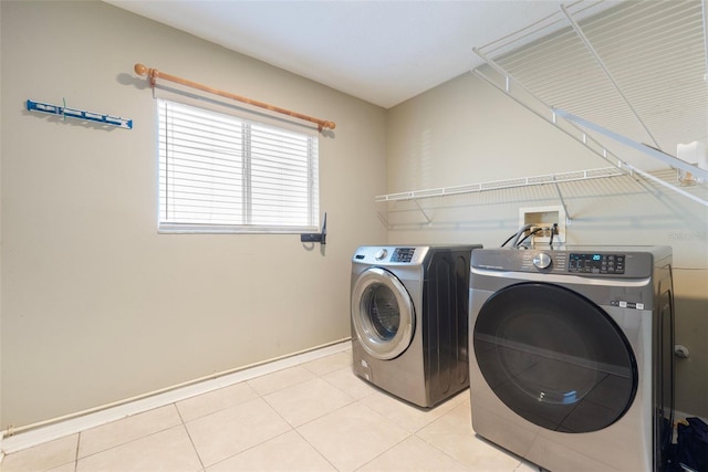 18127 Sandy Pointe Dr, Tampa, FL 33647 - clothes washing area featuring washing machine and dryer, baseboards, and light tile patterned flooring
