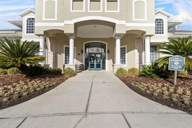 18127 Sandy Pointe Dr, Tampa, FL 33647 - property entrance featuring stone siding, french doors, stucco siding, and covered porch