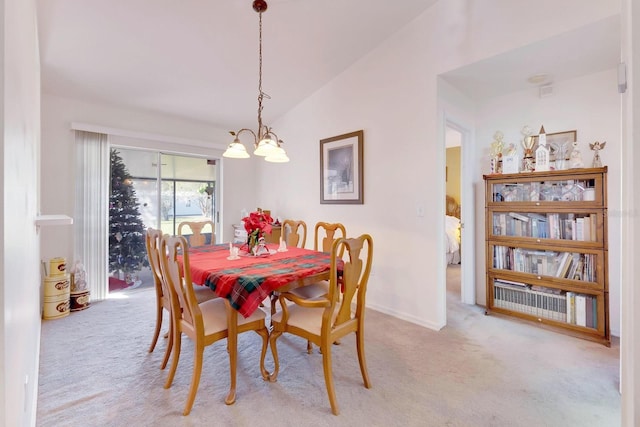 carpeted dining space with vaulted ceiling and an inviting chandelier