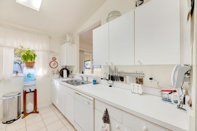 kitchen featuring white cabinets, vaulted ceiling, sink, dishwasher, and light tile patterned flooring