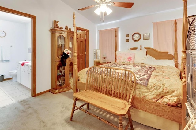 bedroom featuring ceiling fan, lofted ceiling, light carpet, and ensuite bath