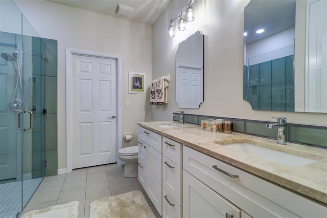 bathroom featuring toilet, vanity, tile patterned floors, and a shower with door