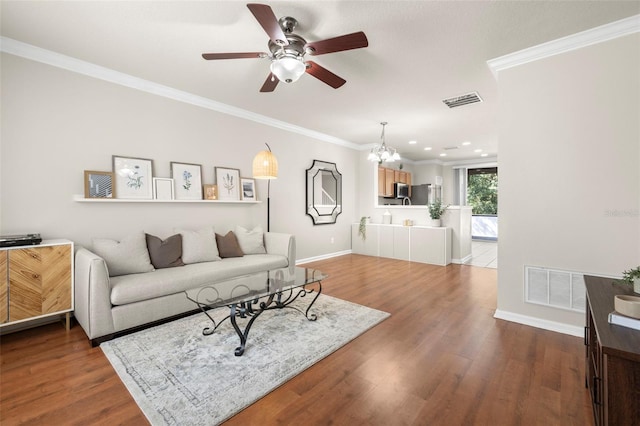 living room with hardwood / wood-style floors, ceiling fan with notable chandelier, and ornamental molding