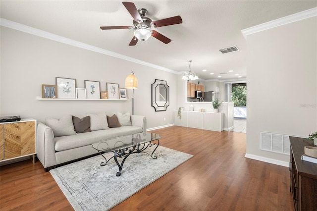 10334 Estero Bay Ln, Tampa, FL 33625 - living room featuring a ceiling fan, wood finished floors, ornamental molding, baseboards, and a chandelier