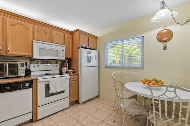 kitchen with pendant lighting, light tile patterned flooring, and white appliances