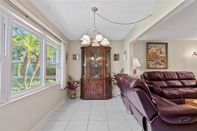 dining area featuring a chandelier, light tile patterned floors, a textured ceiling, and a healthy amount of sunlight