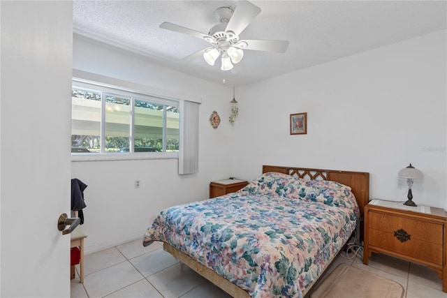 tiled bedroom featuring ceiling fan and a textured ceiling