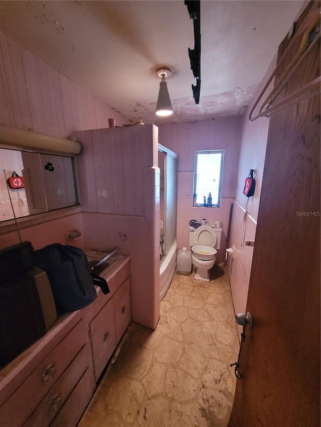 bathroom featuring toilet and enclosed tub / shower combo