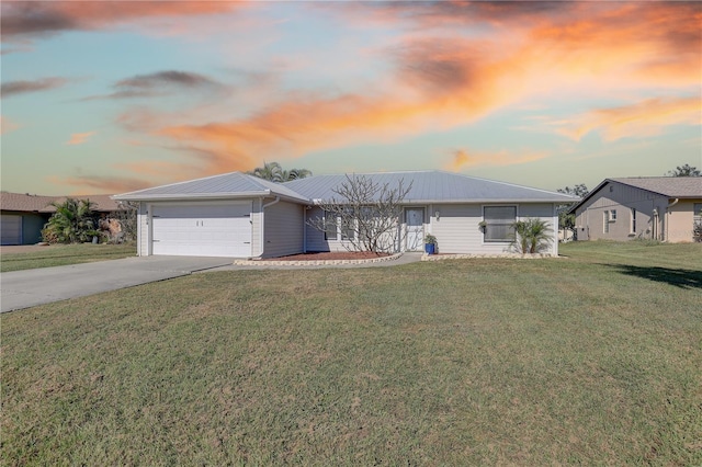 ranch-style house featuring a garage and a lawn