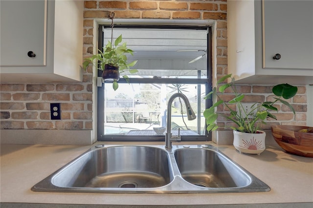 interior details featuring white cabinetry and sink