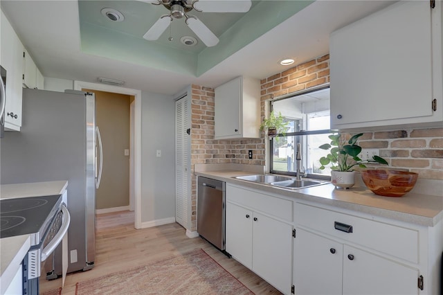 kitchen featuring appliances with stainless steel finishes, white cabinetry, and sink