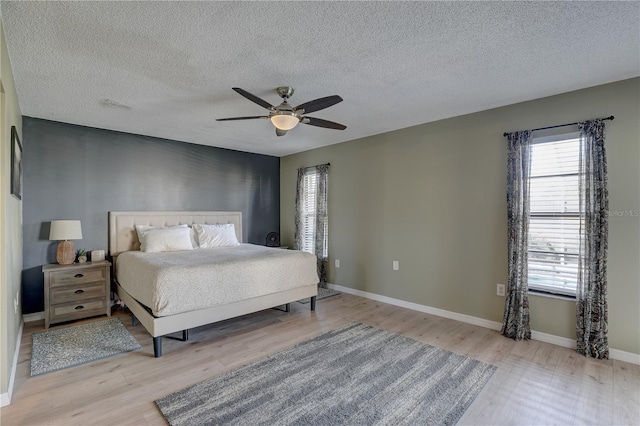 unfurnished bedroom featuring a textured ceiling, light hardwood / wood-style floors, and ceiling fan