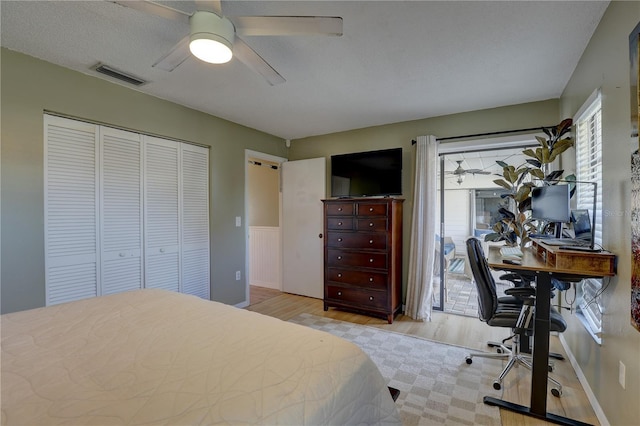 bedroom with ceiling fan, a textured ceiling, access to outside, a closet, and light wood-type flooring