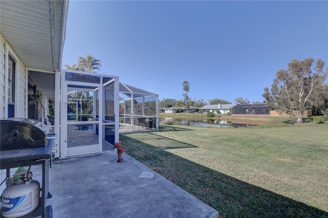 view of yard featuring a lanai, a water view, and a patio