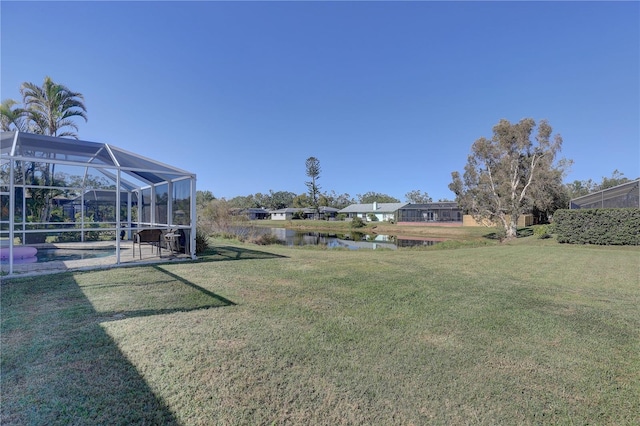 view of yard with a water view and a lanai