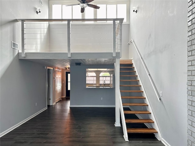 staircase with hardwood / wood-style floors and ceiling fan