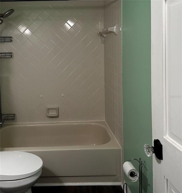 bathroom featuring toilet and tiled shower / bath