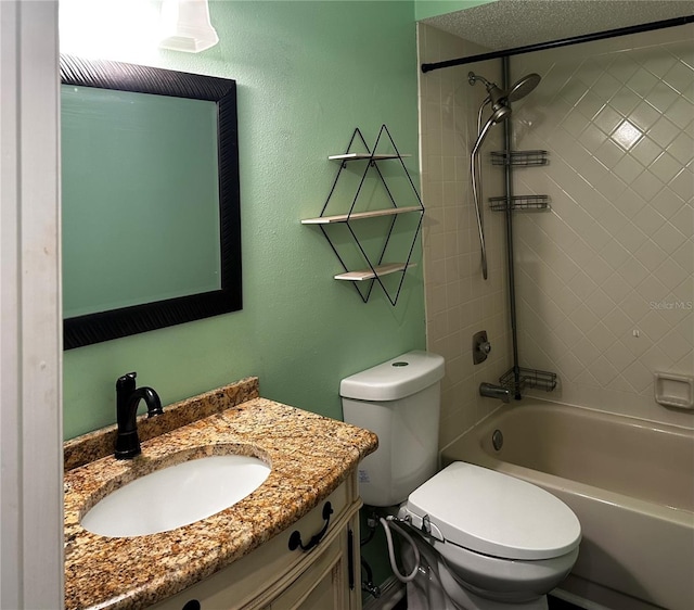 full bathroom featuring toilet, a textured ceiling, vanity, and tiled shower / bath combo