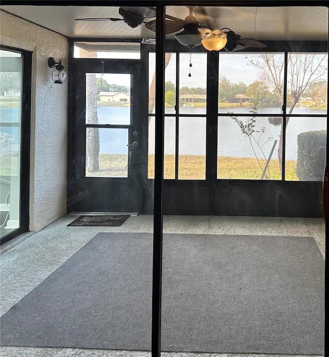 unfurnished sunroom with a wealth of natural light and a water view