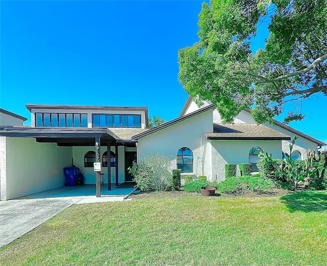 back of house featuring a lawn and a carport