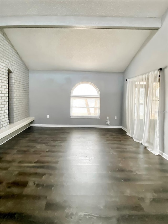 9107 Lingrove Rd, Weeki Wachee, FL 34613 - unfurnished living room with wood finished floors, vaulted ceiling with beams, and baseboards