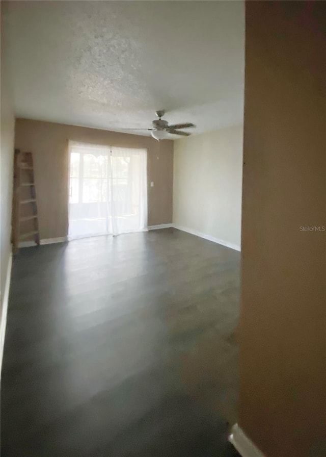 9107 Lingrove Rd, Weeki Wachee, FL 34613 - spare room with finished concrete floors, ceiling fan, a textured ceiling, and baseboards