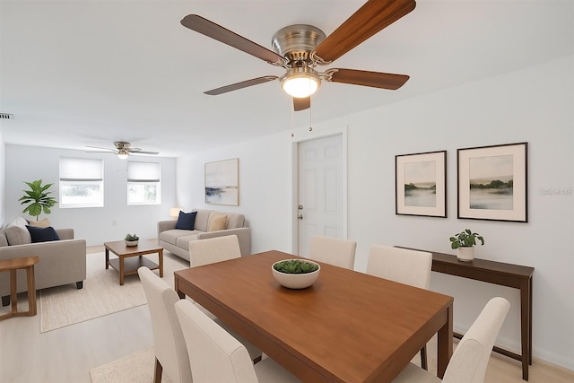 dining area featuring light wood-type flooring, visible vents, and ceiling fan