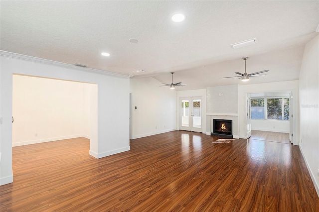 unfurnished living room featuring french doors, a large fireplace, hardwood / wood-style floors, and a textured ceiling