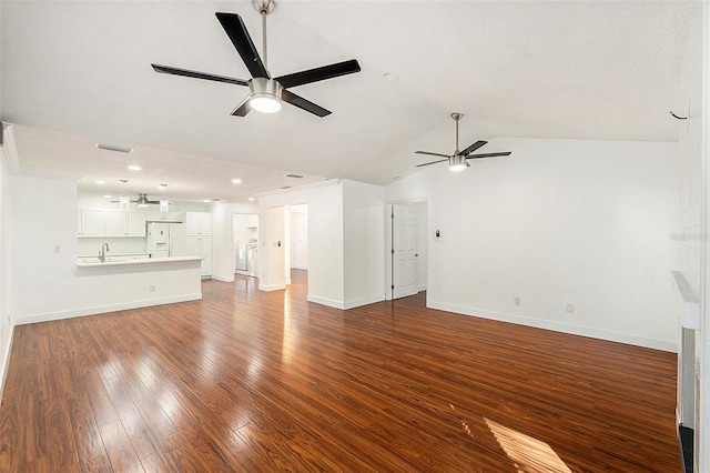 unfurnished living room featuring sink, vaulted ceiling, ceiling fan, a textured ceiling, and dark hardwood / wood-style flooring