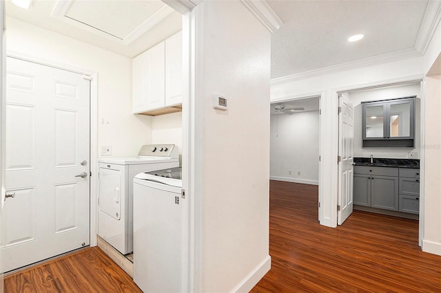 laundry room with crown molding, cabinets, separate washer and dryer, and dark wood-type flooring