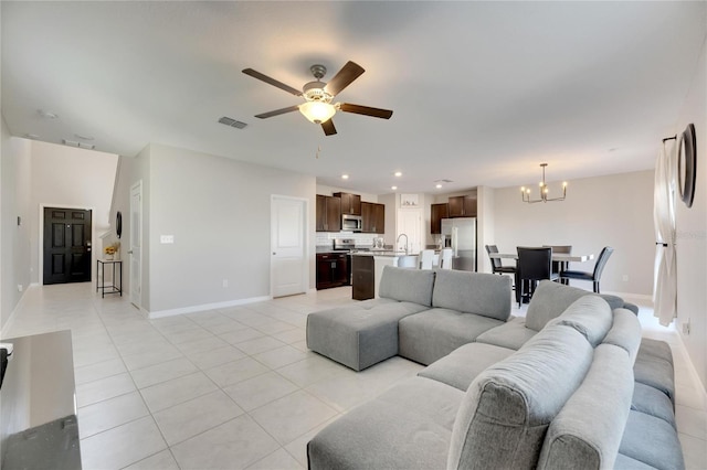 living room featuring light tile patterned floors and ceiling fan with notable chandelier