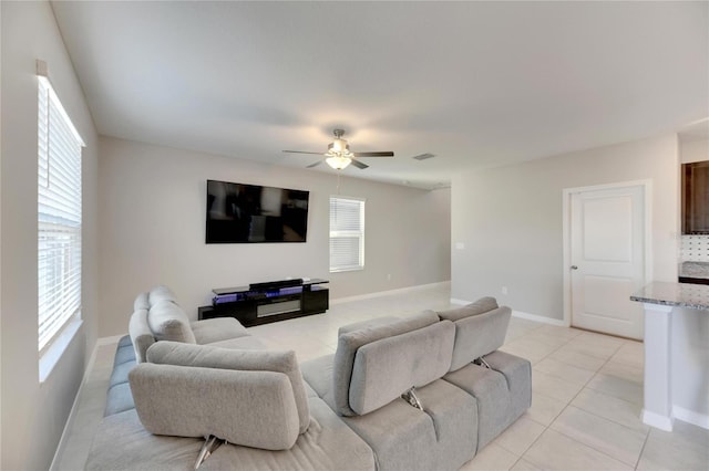 tiled living room featuring ceiling fan and a healthy amount of sunlight