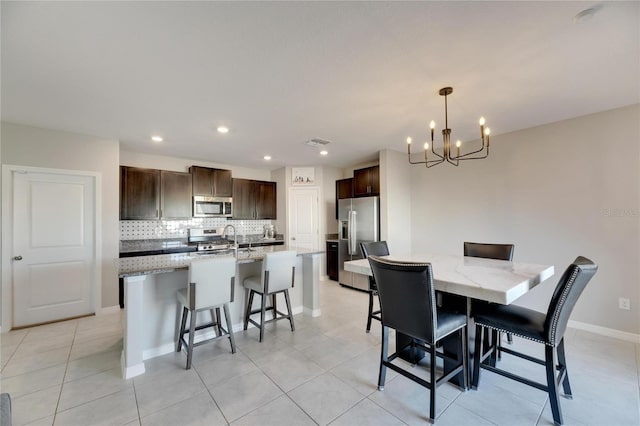 tiled dining space with sink and a chandelier