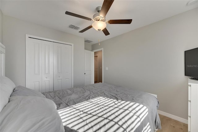 bedroom featuring ceiling fan, light wood-type flooring, and a closet