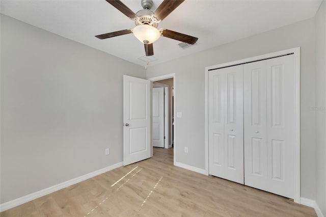 unfurnished bedroom featuring ceiling fan, light wood-type flooring, and a closet