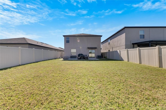 back of property with a patio, a yard, and central AC