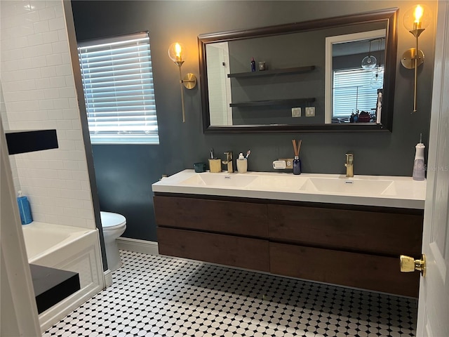 bathroom featuring a bath, vanity, toilet, and tile patterned floors