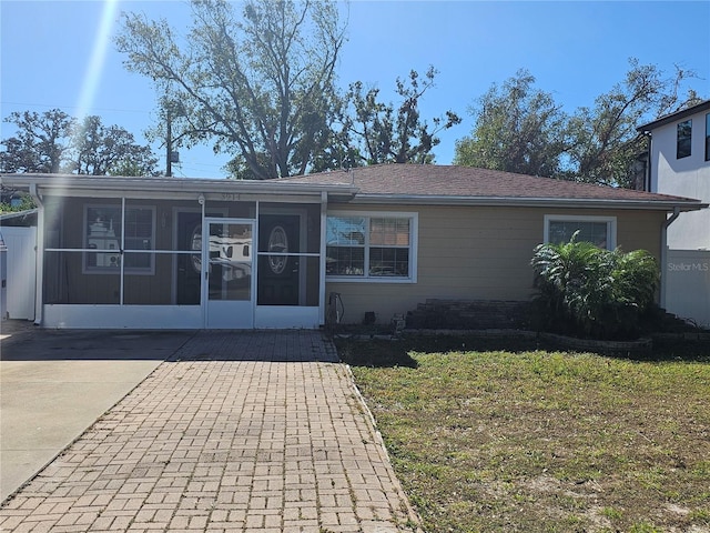 view of front facade featuring a front lawn and a sunroom